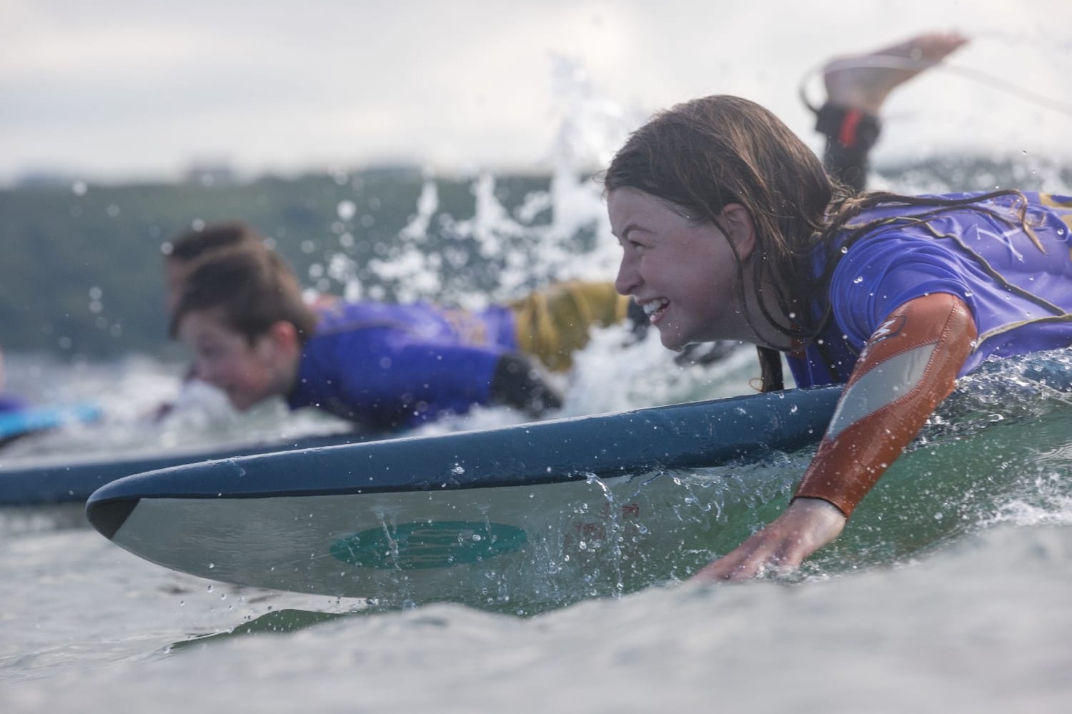 Children learning to surf on the waves at Bude, Cornwall
