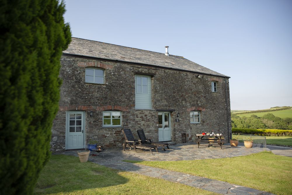 Outdoor dining terrace at Woodlands Manor Farm with valley views