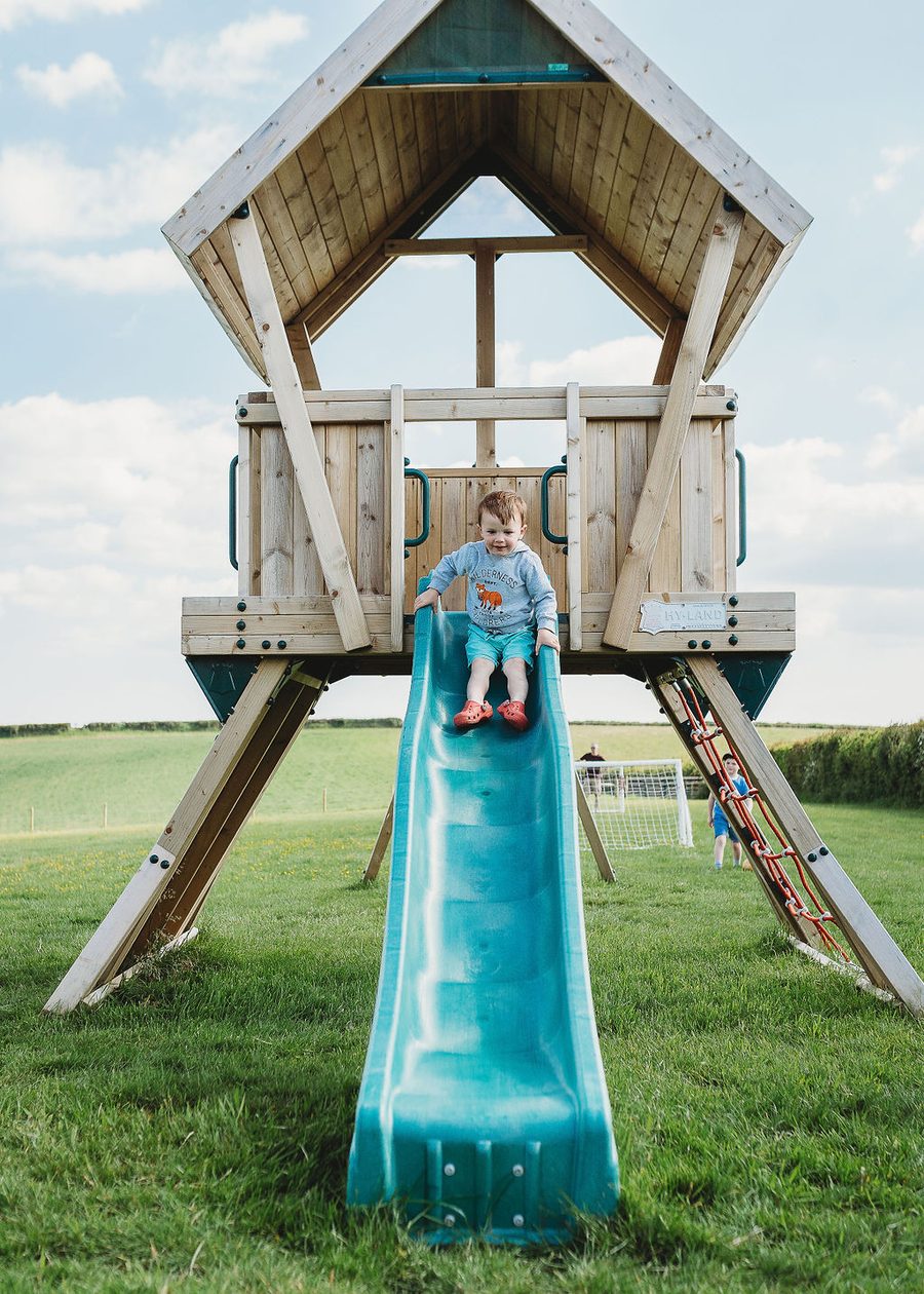 Child on the outdoor playground at Woodlands Manor Farm