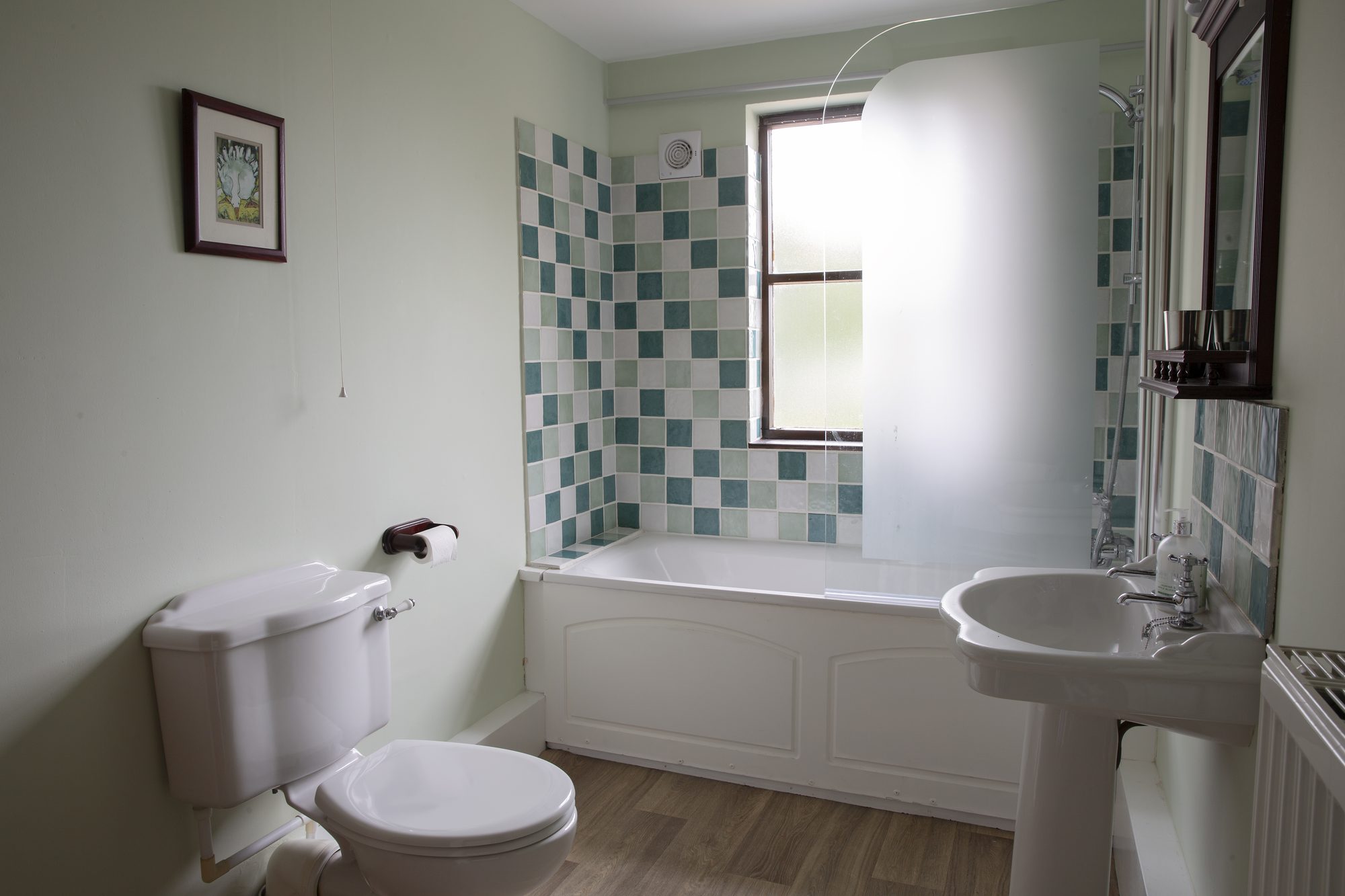 Honeysuckle Cottage bathroom with bath and green tiling