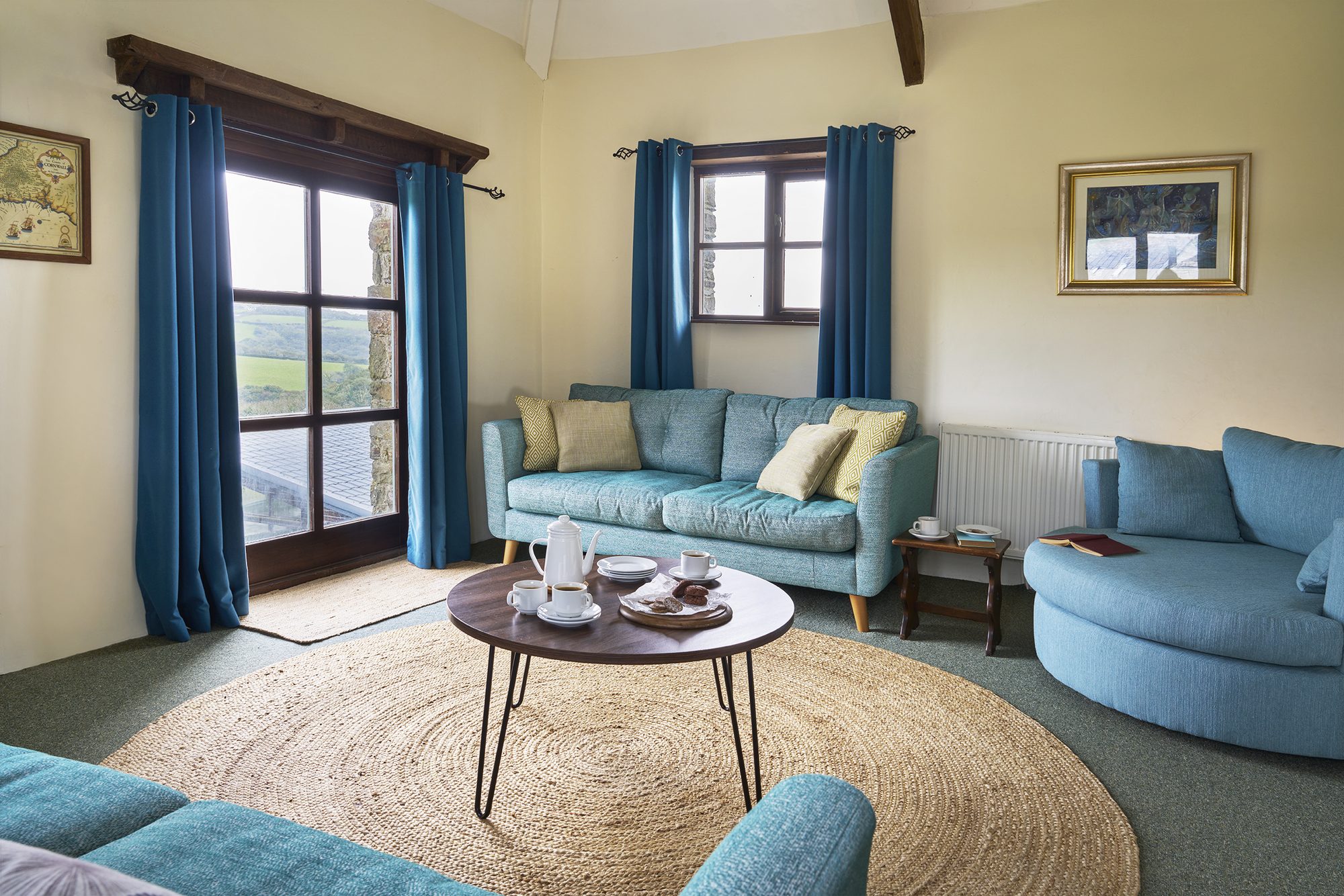 Rose Cottage lounge with round window and comfy sofas
