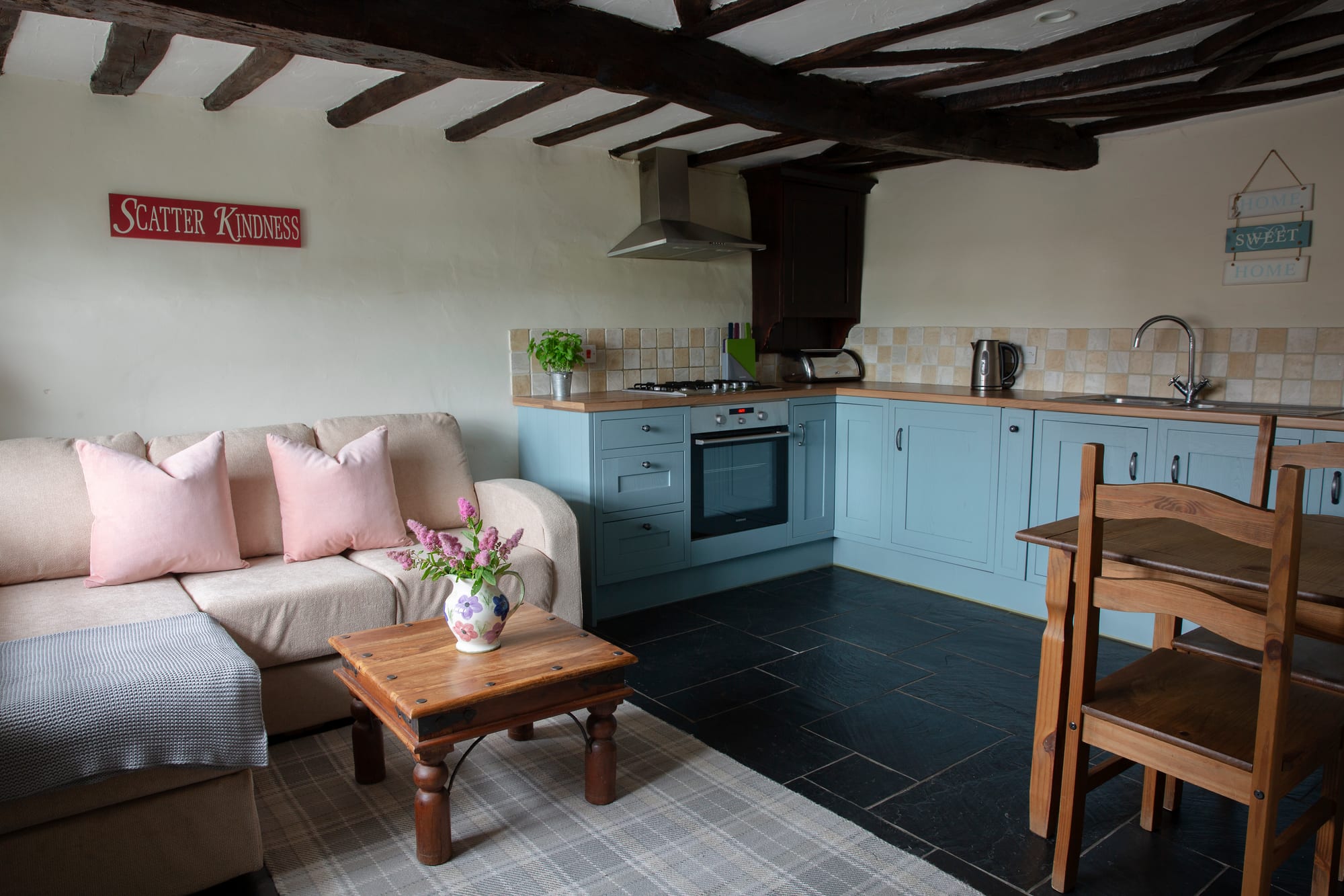 Coach House open-plan living space with corner sofa and kitchen