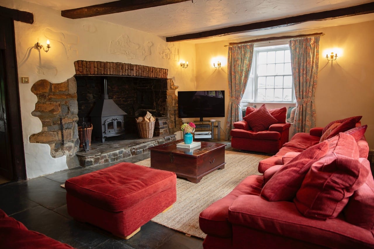 Manor House lounge with the wood burner set in a large stone inglenook