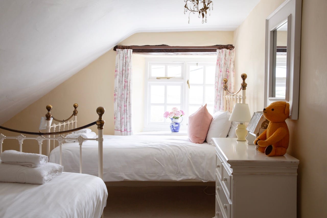 Twin bedroom with iron bedstead and countryside views